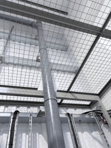 Steel mesh partitioning installed around existing pipework and services inside an industrial workshop