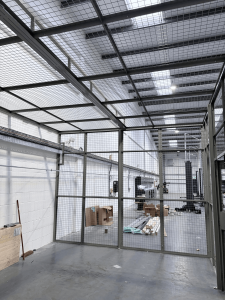 Steel mesh partitioning enclosure with integrated double doors for secure workshop access